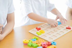 子どもがアルファベットのパズルで遊んでいる