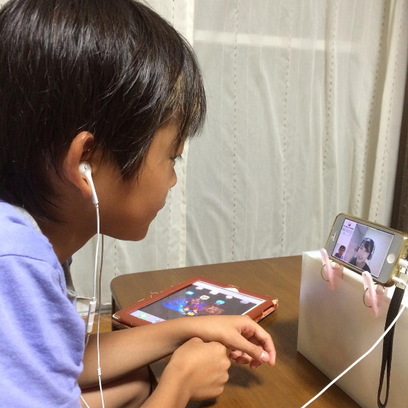 iPhoneで英会話レッスンをする男の子