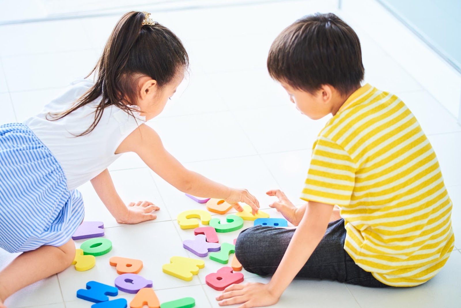 アルファベットのブロックで遊ぶ男の子と女の子