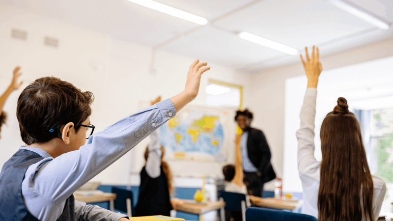 授業中に手を挙げる小学生